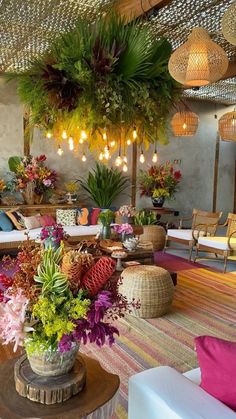 a living room filled with lots of furniture and flowers on top of it's tables