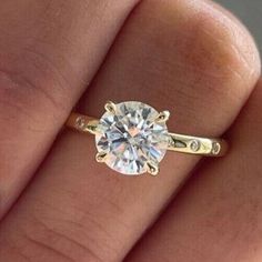 a woman's hand with a yellow gold engagement ring on top of her finger