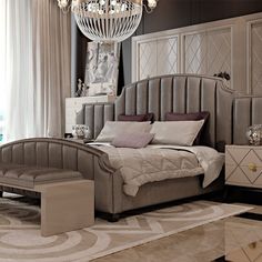 a bedroom with a chandelier hanging from the ceiling and a bed sitting on top of a rug