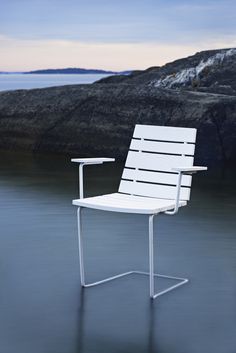 a white chair sitting on top of a body of water