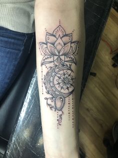 a woman's arm with a tattoo on it and a flower in the middle