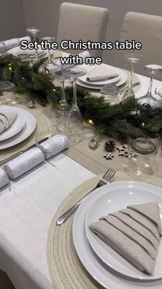 a table set for christmas dinner with place settings