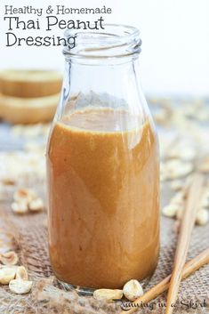 a jar filled with peanut butter next to two wooden spoons