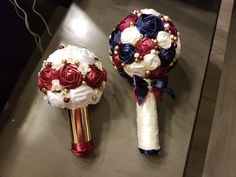 two bridal bouquets with red, white and blue flowers sit on a table