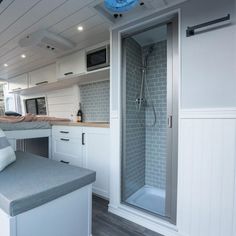 the inside of a camper with a sink, shower and countertop area in it