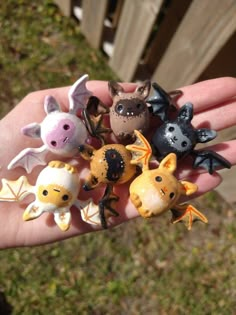 a hand holding several small figurines in it's palm, with various animals on them