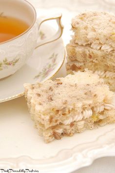 two pieces of cake sitting on top of a plate next to a cup of tea