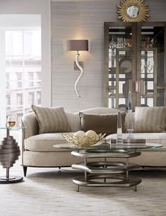 a living room filled with furniture and a large clock on the wall above it's glass table