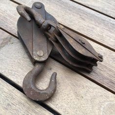 an old pair of hooks sitting on top of a wooden bench