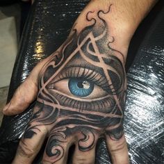 a hand with an all seeing eye tattoo on it