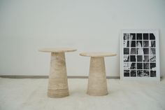 two stone pedestals sitting on top of a white carpet next to a framed photo