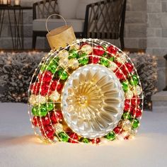 a christmas decoration made out of glass and lights in the snow with a candle holder on top