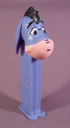 a blue toy with a dog head sticking out of it's side on a purple surface