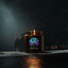 a candle that is sitting on top of a table in front of a dark background