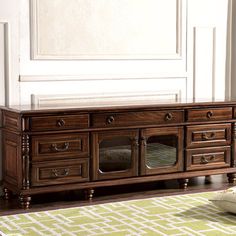 a large wooden entertainment center sitting on top of a green rug in front of a white wall