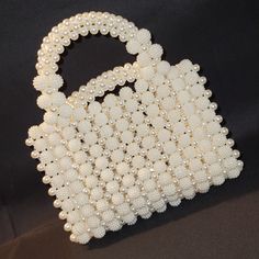 a handbag made out of pearls on a black background