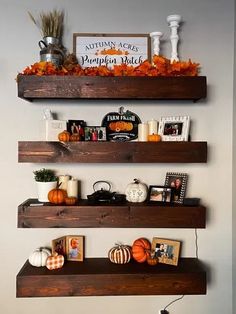 three wooden shelves filled with pumpkins and other decorations