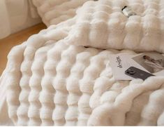 a bed with white blankets and pillows on top of it