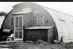 an old black and white photo of a barn