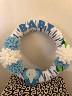 a blue and white baby wreath with an elephant on it's side, sitting on top of a chair