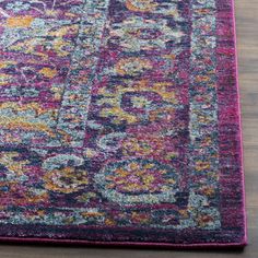 a colorful area rug with an ornate design on the top and bottom, sitting on a wooden floor