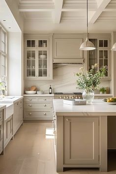 a large white kitchen with lots of counter space and light colored cabinets on the walls