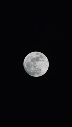 an airplane flying in the sky at night with a full moon behind it and black background