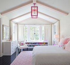 a bedroom with white walls and pink accents