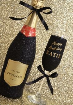 a bottle of champagne next to a wine glass with a happy birthday message on it