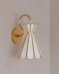 a wall light that is on the side of a wall with a white and gold shade