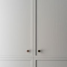 two white cupboards with brass handles and knobs on the doors are shown in this image