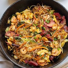 a wok filled with stir fry vegetables and shrimp