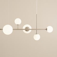 an overhead light fixture with five white globes hanging from it's center bar