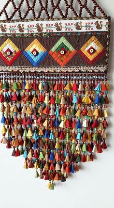 a multicolored wall hanging with many tassels