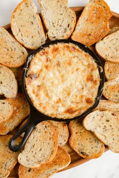 a skillet filled with cheesy bread on top of a table