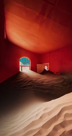 an empty room with red walls and sand dunes