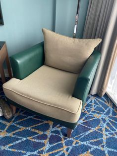 a chair sitting on top of a blue carpet next to a window