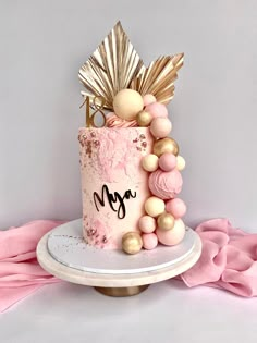 a pink cake with gold decorations on top