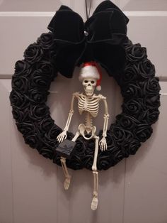 a wreath with a skeleton on it hanging from the front door