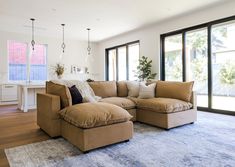 a living room filled with furniture and lots of windows