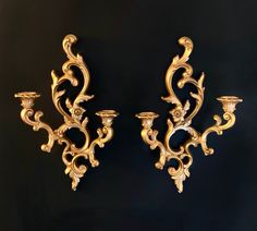 two golden wall sconces on a black background