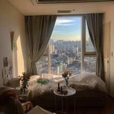 a bedroom with a large window overlooking the city