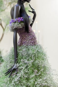 a mannequin with flowers and grass on it