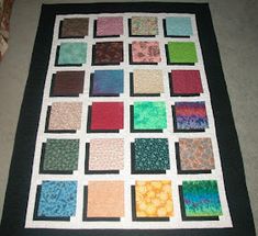 a quilt made to look like it has different colors on it and is sitting on the floor