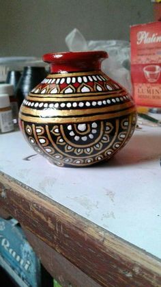 a vase sitting on top of a wooden table next to other items and boxes in the background