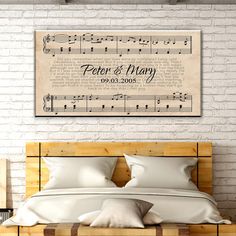 a bed with sheet music on the wall above it and pillows in front of it