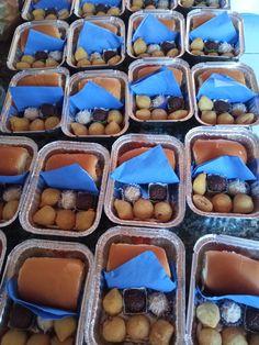 several trays filled with different types of food and some blue napkins on top of them