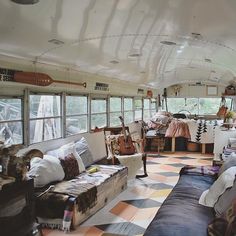 the inside of an old bus with lots of furniture and decorations on it's walls