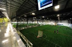 an indoor soccer field with people playing on it