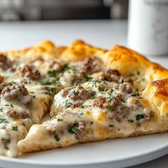 a close up of a slice of pizza on a plate with a cup in the background